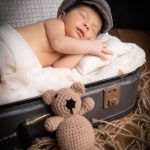 Bebé recién nacido durmiendo abrazado a un osito durante una sesión newborn en Murcia.